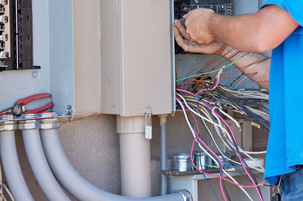 electrician rewiring an electrical service panel