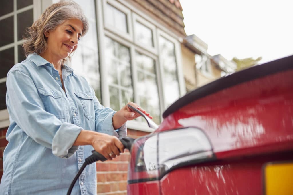 Woman charging an electric car at home